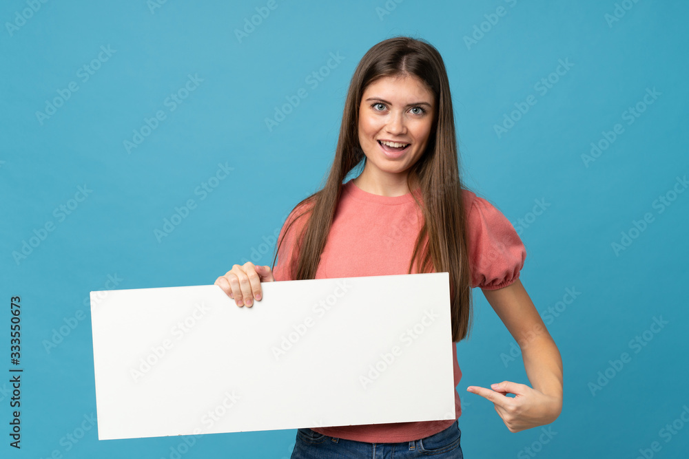 Young woman over isolated blue background holding an empty white placard for insert a concept Young woman over isolated blue background holding an empty white placard for insert a concept
