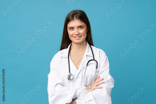 Young woman over isolated blue background with doctor gown