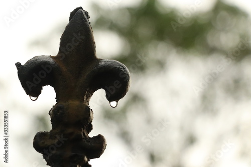 STEEL OBJECT WITH RAINDROPS WITH BLURRY BACKGROUND.