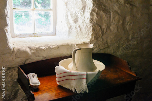 фотографія Old fashioned wash jug and basin by the window of a traditional Irish farmhouse