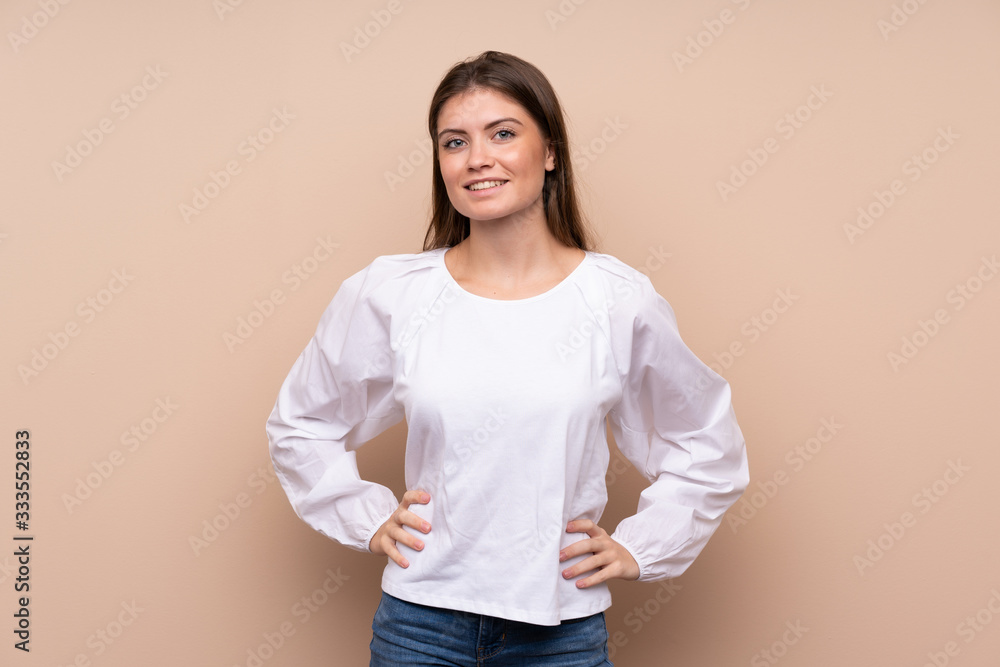 Young girl over isolated background posing with arms at hip and smiling Young girl over isolated background posing with arms at hip and smiling