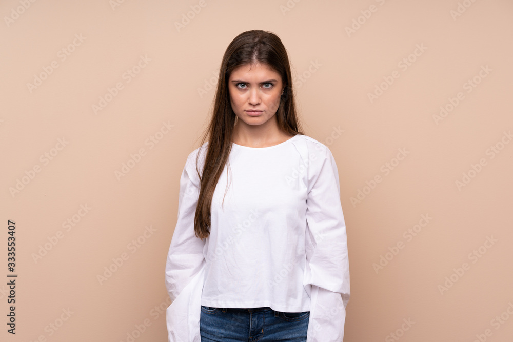 Obraz premium Young girl over isolated background with sad and depressed expression