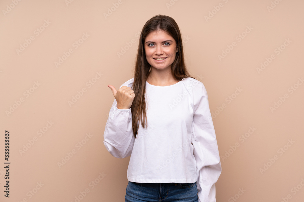 Young girl over isolated background pointing to the side to present a product Young girl over isolated background pointing to the side to present a product