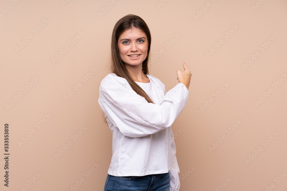 Young girl over isolated background pointing back Young girl over isolated background pointing back