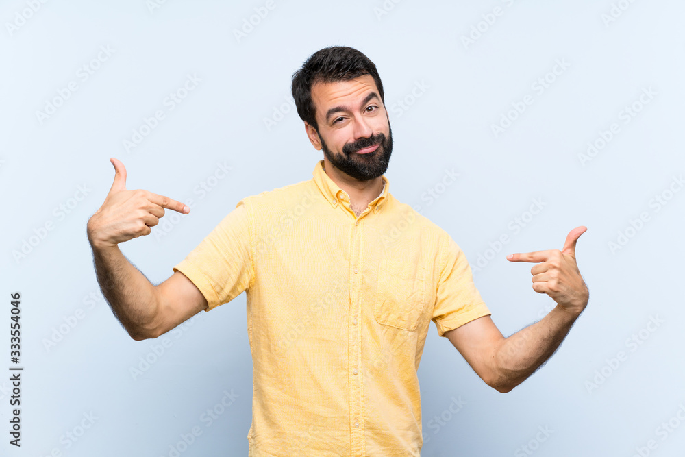 Young man with beard over isolated blue background proud and self-satisfied Young man with beard over isolated blue background proud and self-satisfied