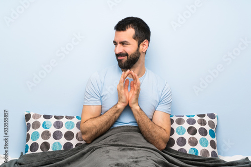 Man in bed scheming something