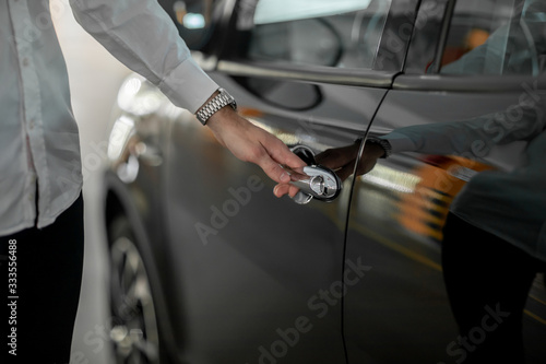 male hand holds a black car door handle