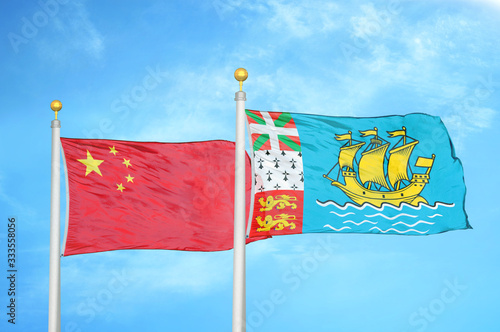 China and Saint Pierre and Miquelon two flags on flagpoles and blue cloudy sky photo