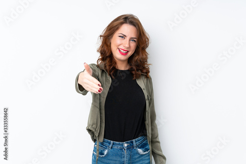 Young Russian woman over isolated white background shaking hands for closing a good deal