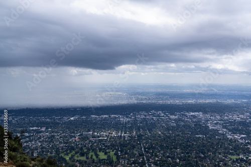 Fototapeta Naklejka Na Ścianę i Meble -  Mountaintop view of storm clouds and rain moving into Pasadena in Los Angeles County California.