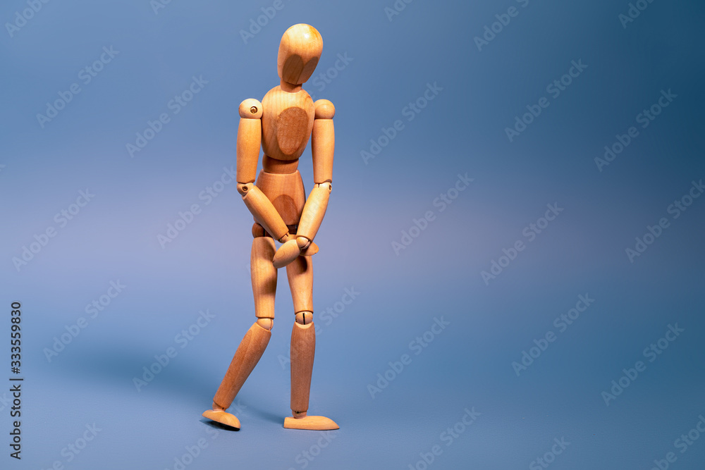 Wooden man with bladder control problem on blue background