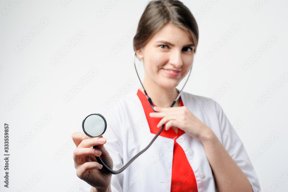 Portrait of smiling lady medical professional in white coat holding phonendoscope looking directly at the camera Portrait of smiling lady medical professional in white coat holding phonendoscope looking directly at the camera