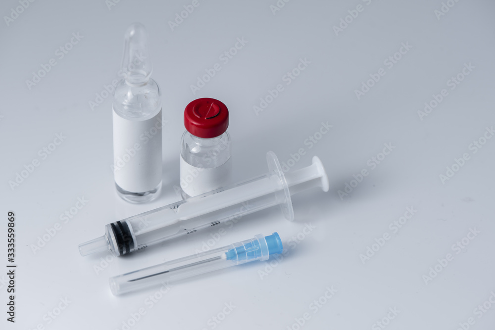 Medical vials for injection and a syringe, on white background Medical vials for injection and a syringe, on white background