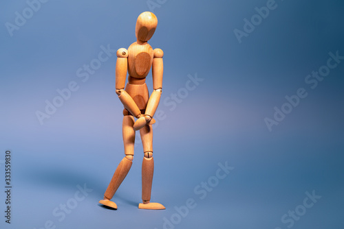 Obraz na płótnie Wooden man with bladder control problem on blue background w salonie