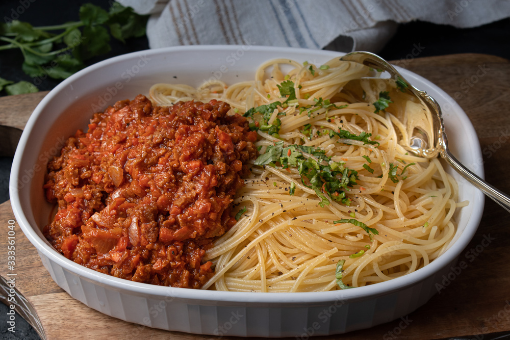 Vegan seitan spaghetti bolognese in white serving dish Vegan seitan spaghetti bolognese in white serving dish