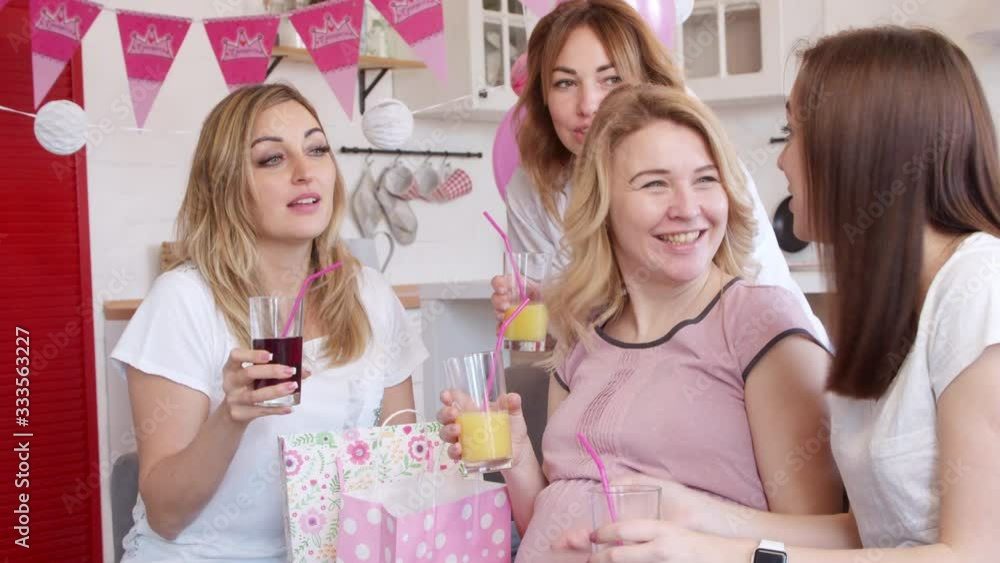 Pregnant woman getting gift at baby shower party Pregnant woman getting gift at baby shower party