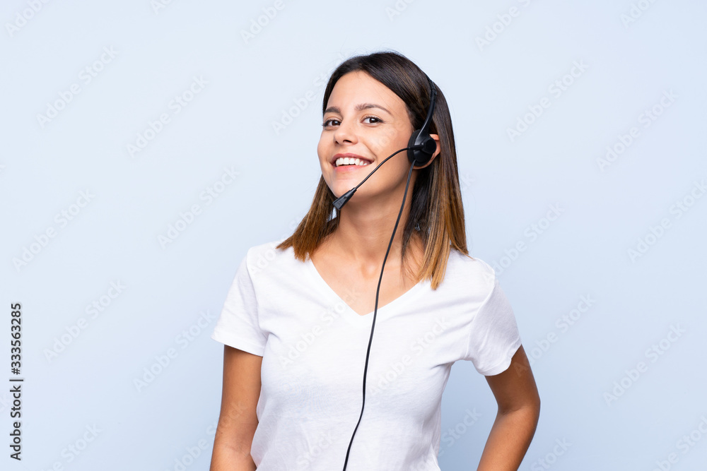 Young woman over isolated blue background working with headset Young woman over isolated blue background working with headset