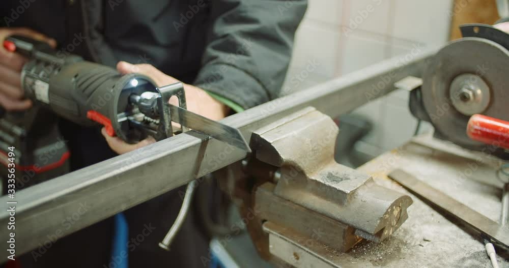 industry worker metal part with electric hacksaw industry worker metal part with electric hacksaw