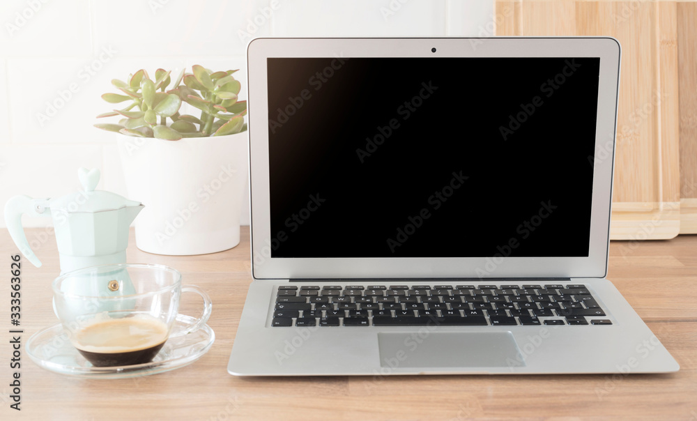 Home Office. Working From Home. Laptop With Blank Screen. Cup Of Coffee And Italian Coffee Maker In Blue. Bright And Clean Kitchen, Close Up. Cutting Boards, Green Succulent Pot On Wooden Worktop Home Office. Working From Home. Laptop With Blank Screen. Cup Of Coffee And Italian Coffee Maker In Blue. Bright And Clean Kitchen, Close Up. Cutting Boards, Green Succulent Pot On Wooden Worktop