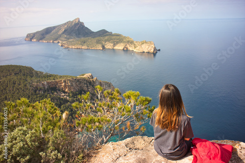 Beautiful young woman going for trekking and looking to the dragonera island in the mediterranean sea © Jaime