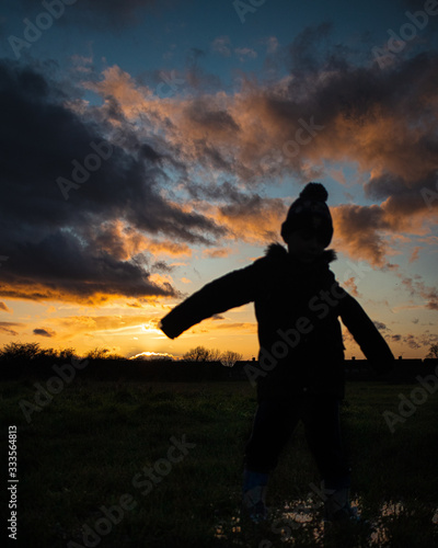 silhouette of boy and dramatic sunset
