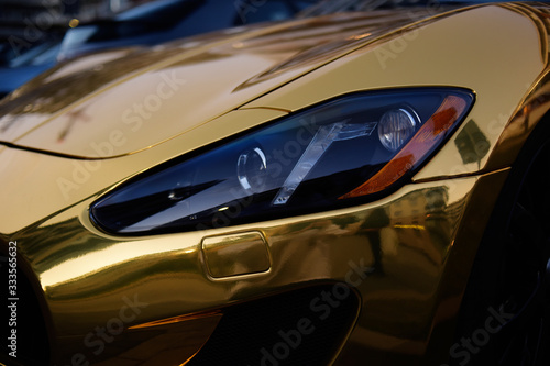 A golden car, a golden car on the street, a luxury car.