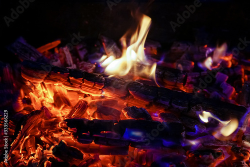Burning firewood in the fireplace close up, BBQ fire, charcoal background. Charcoal fire with sparks © zamuruev