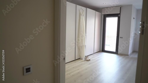 Amazing dress bride hanging over closet door and the wedding shoes below 