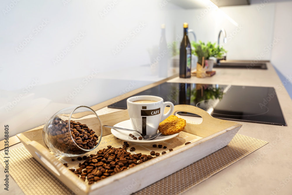 A tray of coffee with spilled coffee beans on a table.