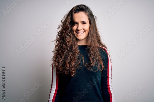 Young beautiful woman with curly hair wearing casual sweater over isolated white background with a happy and cool smile on face. Lucky person.