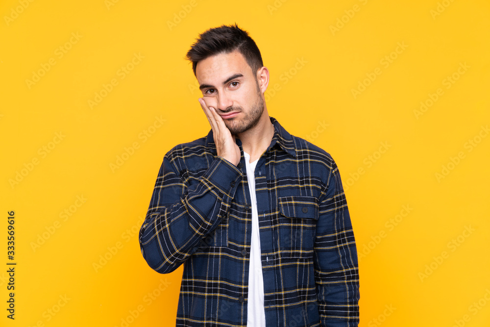 Young handsome man over isolated yellow background unhappy and frustrated Young handsome man over isolated yellow background unhappy and frustrated