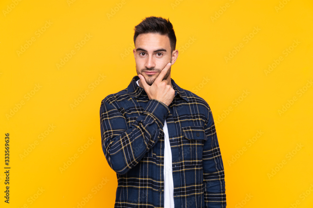 Young handsome man over isolated yellow background thinking an idea Young handsome man over isolated yellow background thinking an idea