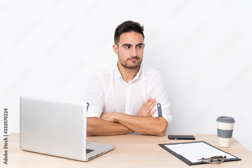 Young business man with a mobile phone in a workplace thinking an idea Young business man with a mobile phone in a workplace thinking an idea