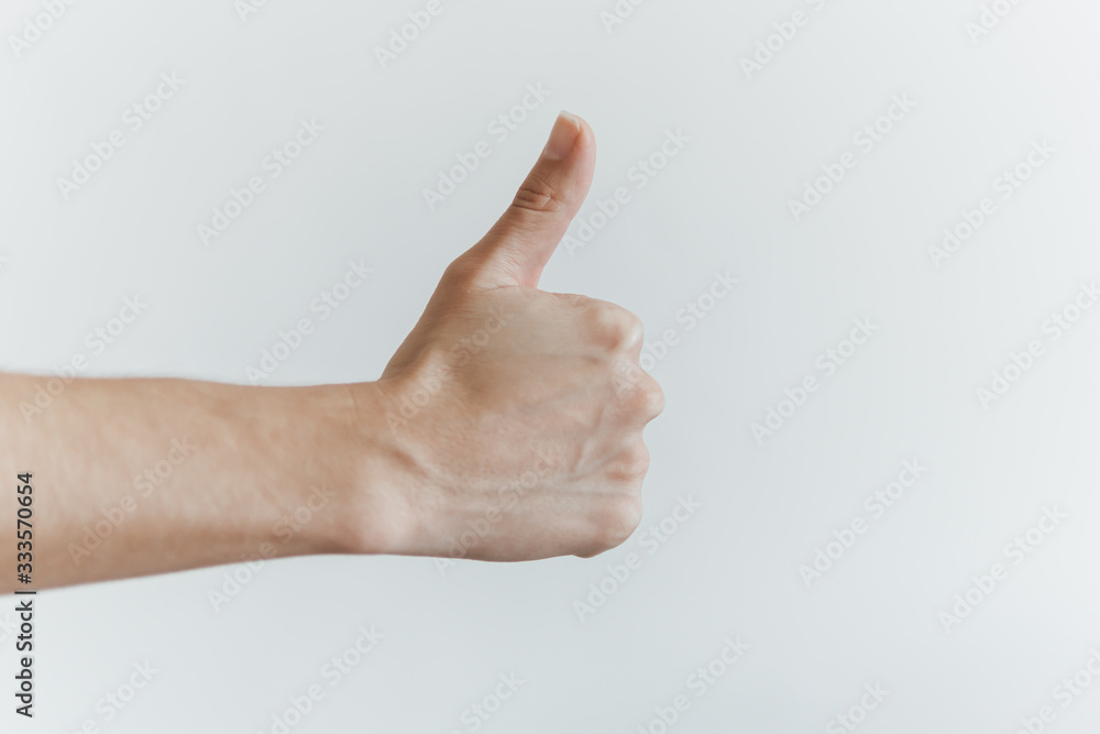 Mão de mulher branca fazendo sinal de positivo.