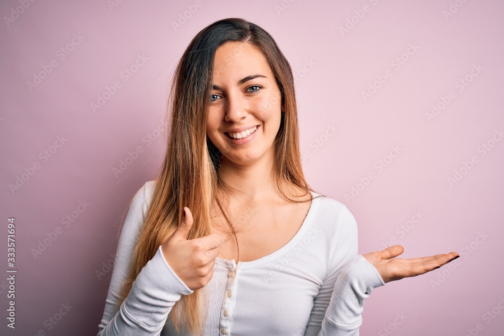 Young beautiful blonde woman with blue eyes wearing white t-shirt over pink background Showing palm hand and doing ok gesture with thumbs up, smiling happy and cheerful Young beautiful blonde woman with blue eyes wearing white t-shirt over pink background Showing palm hand and doing ok gesture with thumbs up, smiling happy and cheerful