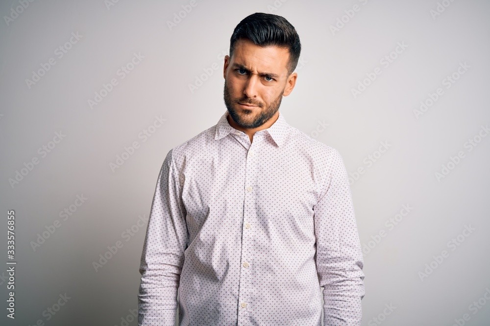 Young handsome man wearing elegant shirt standing over isolated white background skeptic and nervous, frowning upset because of problem. Negative person.