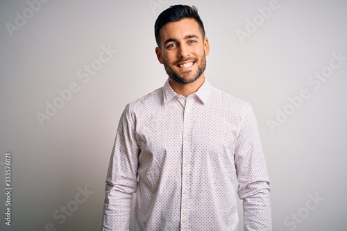 Young handsome man wearing elegant shirt standing over isolated white background with a happy and cool smile on face. Lucky person.