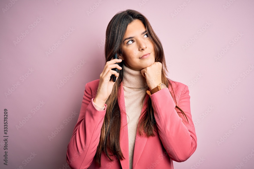 Young beautiful girl having conversation talking on the smartphone over white background serious face thinking about question, very confused idea Young beautiful girl having conversation talking on the smartphone over white background serious face thinking about question, very confused idea