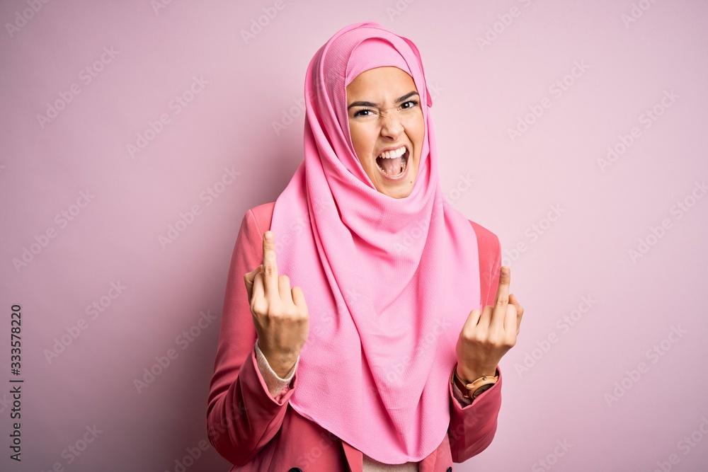 Young beautiful girl wearing muslim hijab standing over isolated pink  background Showing middle finger doing fuck you bad expression, provocation  and rude attitude. Screaming excited Stock Photo | Adobe Stock