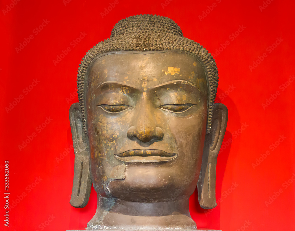 Head of the Buddha Statue on red background