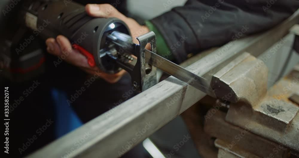 industry worker metal part with electric hacksaw industry worker metal part with electric hacksaw