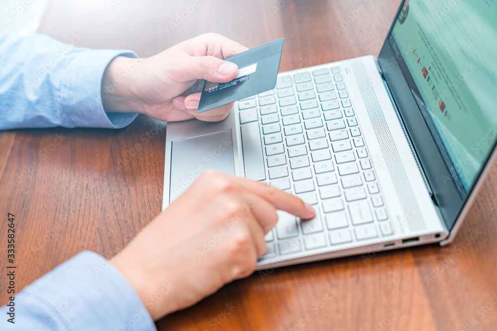 Consumer shopping online with credit card in hand Consumer shopping online with credit card in hand