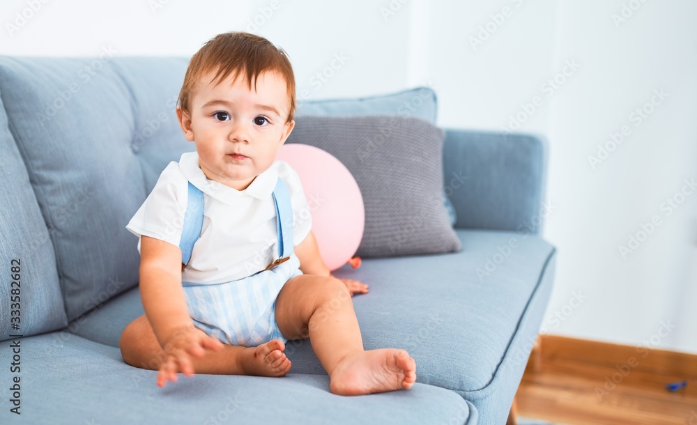Adorable toddler sitting on the sofa at home Adorable toddler sitting on the sofa at home