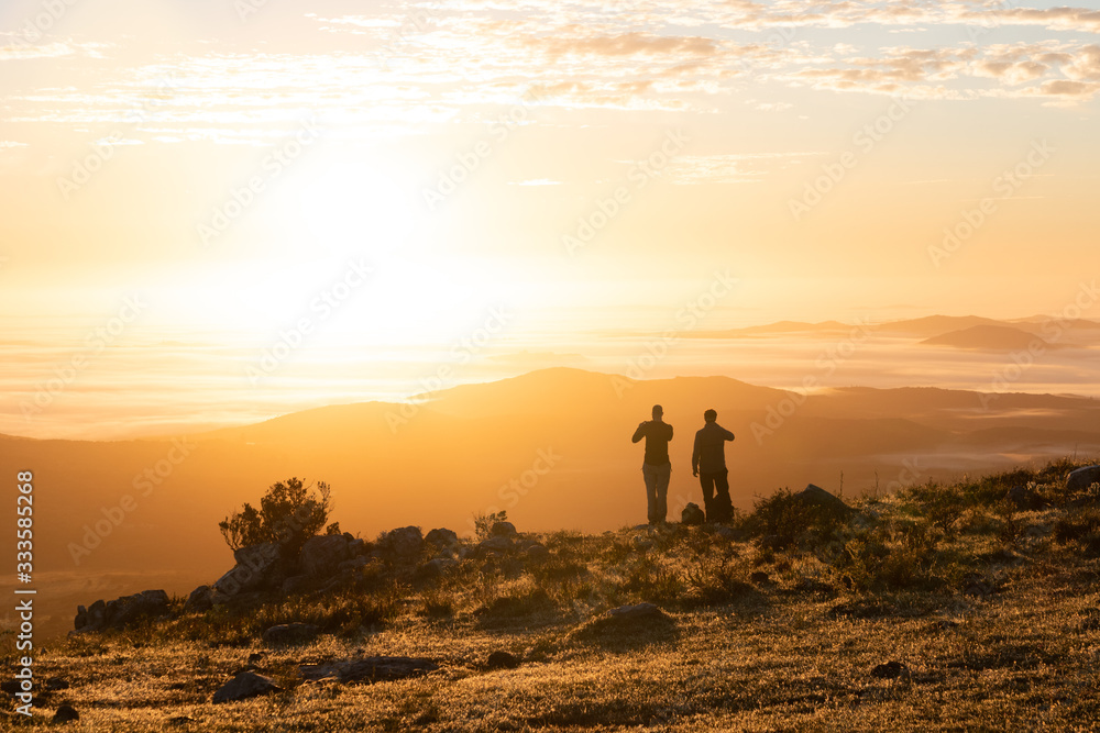 two people looking at the sunrise on the golden hour