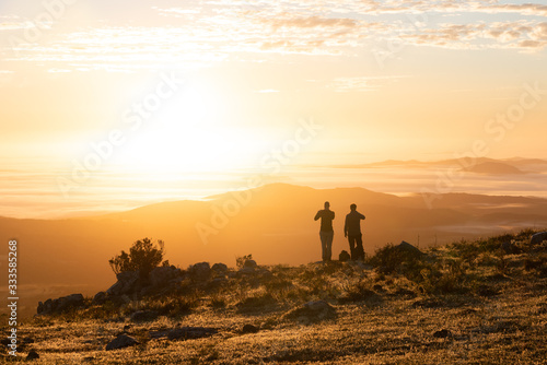 two people looking at the sunrise on the golden hour