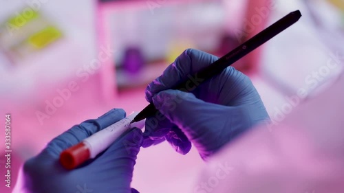 Noting tampon with Coronavirus test exemplar for analysis on laboratory by scientist wearing gloves