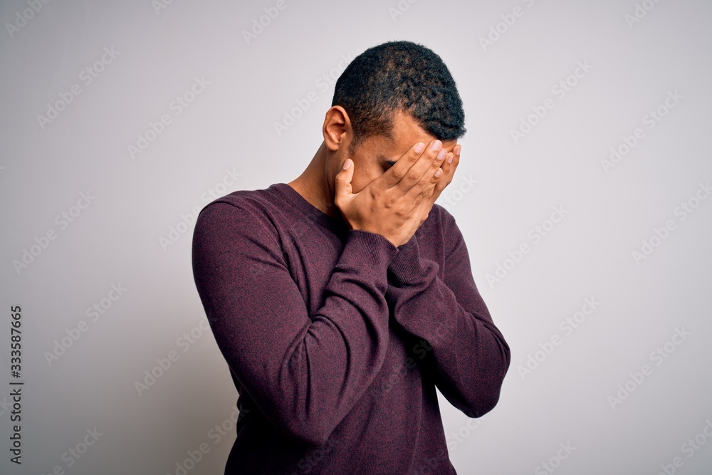 Young handsome african american man wearing casual sweater over white background with sad expression covering face with hands while crying. Depression concept. Young handsome african american man wearing casual sweater over white background with sad expression covering face with hands while crying. Depression concept.