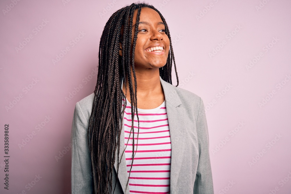 Young african american business woman standing over pink isolated background looking away to side with smile on face, natural expression. Laughing confident. Young african american business woman standing over pink isolated background looking away to side with smile on face, natural expression. Laughing confident.