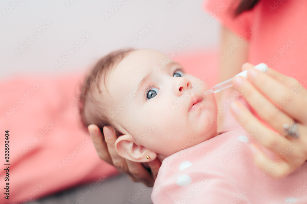 Mother Administrating Vitamin D Medicine to her Baby Mother Administrating Vitamin D Medicine to her Baby