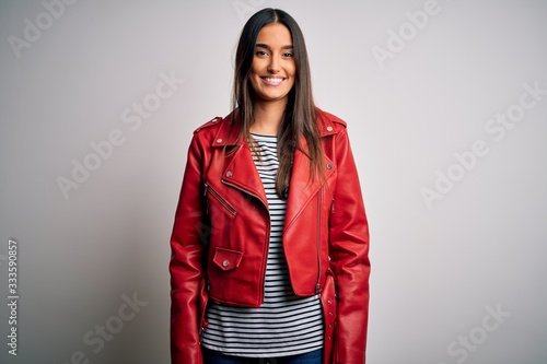 Young beautiful brunette woman wearing casual striped t-shirt and red jacket with a happy and cool smile on face. Lucky person.